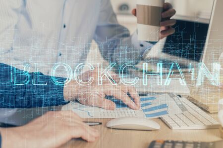 Crypto currency theme hologram with businessman working on computer on background. Concept of blockchain. Multi exposure.の写真素材
