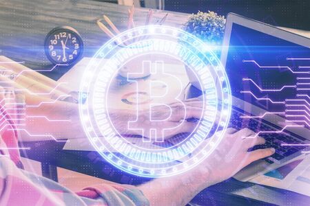 Crypto currency theme hologram with businessman working on computer on background. Concept of blockchain. Multi exposure.の写真素材