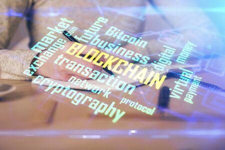 Cryptocurrency hologram over woman's hands writing background. Concept of blockchain. Multi exposureの写真素材