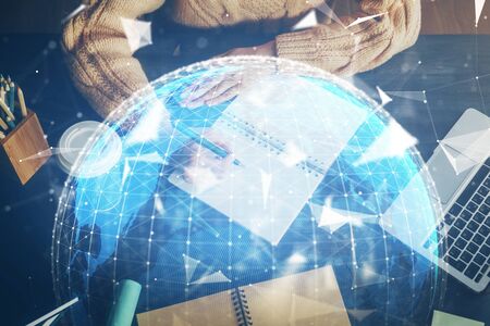 International business hologram over woman's hands taking notes background. Concept of success. Double exposureの写真素材