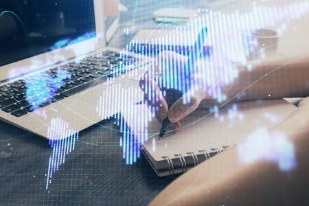 International business hologram over woman's hands taking notes background. Concept of success. Double exposureの写真素材