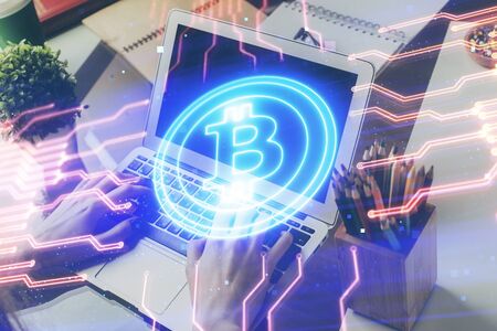 Crypto currency theme hologram with businessman working on computer on background. Concept of blockchain. Double exposure.の写真素材