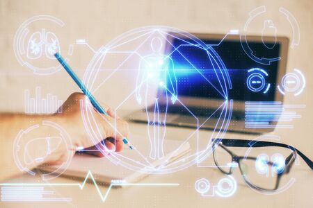 Mans hands working with notes background. Modern computer record diagram with virtual mnitor.の写真素材