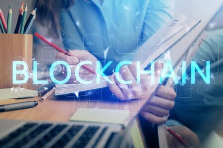 Cryptocurrency hologram over womans hands writing background. Concept of blockchain. Multi exposureの写真素材