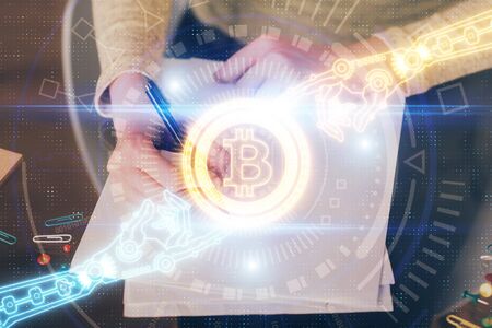 Cryptocurrency hologram over womans hands writing background. Concept of blockchain. Multi exposureの写真素材