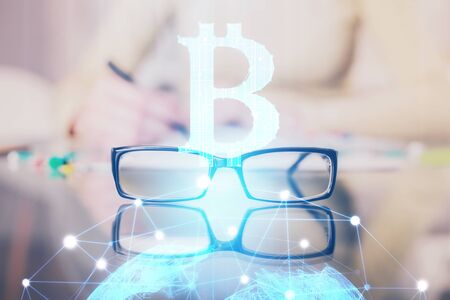 Cryptocurrency hologram over womans hands writing background. Concept of blockchain. Multi exposureの写真素材