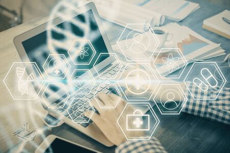 DNA hologram with businessman working on computer on background. Concept of bioengineering. Double...