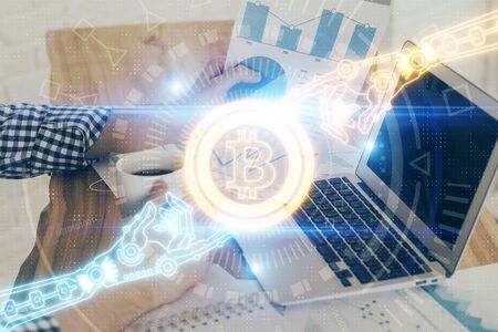 Crypto currency theme hologram with businessman working on computer on background. Concept of...