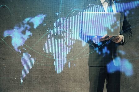 Double exposure of businessman working on laptop on background. International business hologram in front. Concept of success.の写真素材