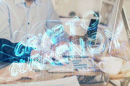 Crypto currency theme hologram with businessman working on computer on background. Concept of...