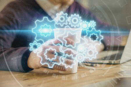 Double exposure of businessman working on laptop on background. International business hologram in...