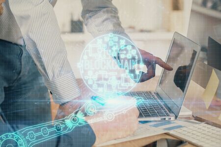 Crypto currency theme hologram with businessman working on computer on background. Concept of blockchain. Multi exposure.の写真素材