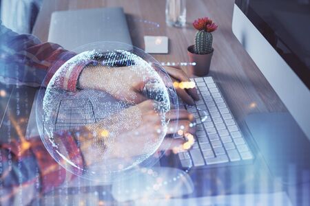 Multi exposure of world map hologram with man working on computer on background. Concept of worldwideweb.の写真素材