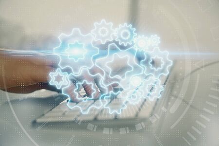 Double exposure of businessman working on laptop on background. International business hologram in...