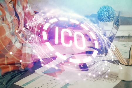 Crypto currency theme hologram with businessman working on computer on background. Concept of blockchain. Multi exposure.の写真素材