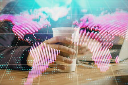 Double exposure of businessman working on laptop on background. International business hologram in front. Concept of success.の写真素材