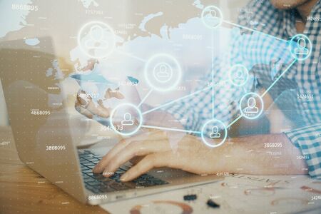 Social network theme hologram with businessman working on computer on background. Concept of world wide web. Double exposure.の写真素材