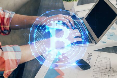 Crypto currency theme hologram with businessman working on computer on background. Concept of blockchain. Multi exposure.の写真素材