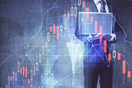 Forex graph with businessman working on laptop on background. Concept of hardworking. Multi...