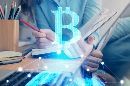 Cryptocurrency hologram over womans hands writing background. Concept of blockchain. Multi exposureの写真素材