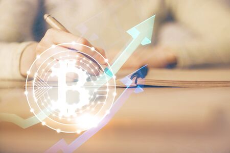 Cryptocurrency hologram over womans hands writing background. Concept of blockchain. Multi exposureの写真素材