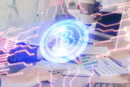 Crypto currency theme hologram with businessman working on computer on background. Concept of blockchain. Multi exposure.の写真素材
