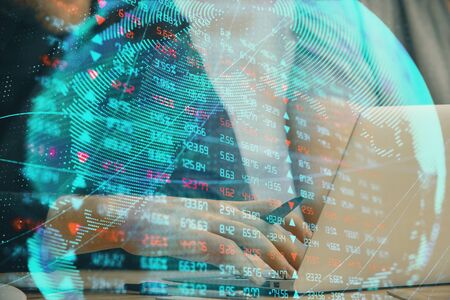 Double exposure of businessman working on laptop on background. International business hologram in...