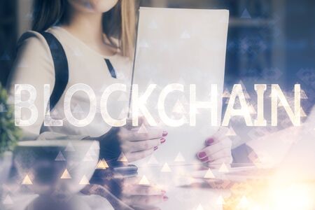 Cryptocurrency hologram over woman's hands writing background. Concept of blockchain. Double exposureの写真素材