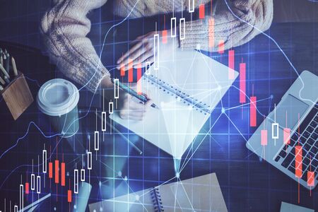 Forex graph on hand taking notes background. Concept of research. Double exposureの写真素材