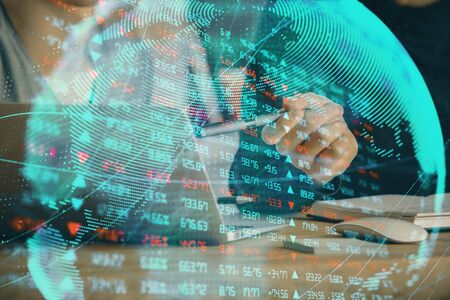 Double exposure of businessman working on laptop on background. International business hologram in front. Concept of success.の写真素材