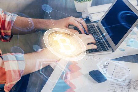 Crypto currency theme hologram with businessman working on computer on background. Concept of...