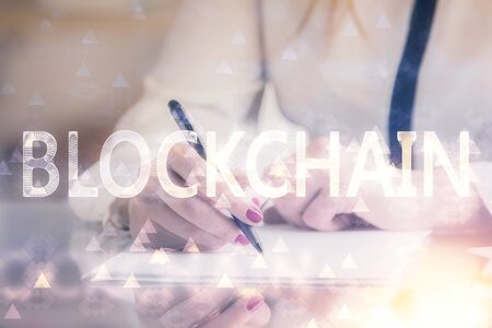 Cryptocurrency hologram over woman's hands writing background. Concept of blockchain. Double exposureの写真素材
