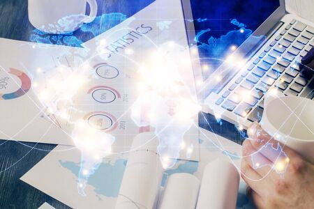 Double exposure of businessman working on laptop on background. International business hologram in...