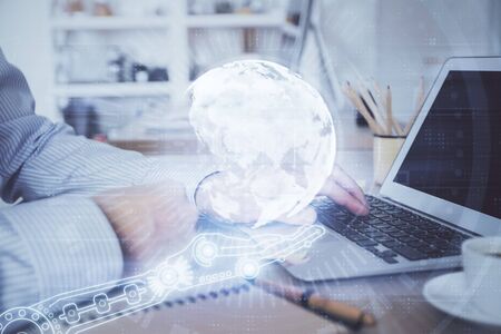Multi exposure of world map hologram with man working on computer on background. Concept of worldwideweb.の写真素材