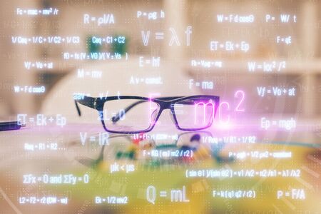 Formulas drawing with glasses on the table background. Concept of science. Double exposure.の写真素材