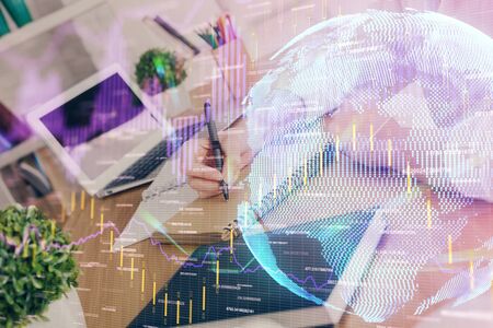 Financial graph displayed on womans hand taking notes background. Concept of research. Double exposureの写真素材