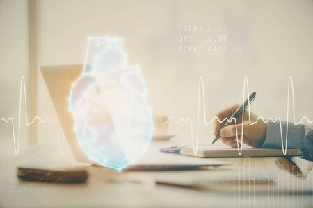 Heart drawing with man working on computer on background. Medical concept. Double exposure.の写真素材