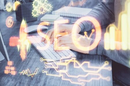 Double exposure of seo icon with man working on computer on background. Concept of search engine optimization.の写真素材