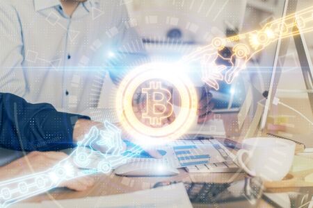 Crypto currency theme hologram with businessman working on computer on background. Concept of blockchain. Multi exposure.の写真素材