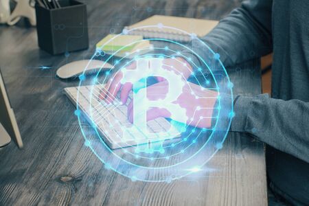 Crypto currency theme hologram with businessman working on computer on background. Concept of blockchain. Multi exposure.の写真素材
