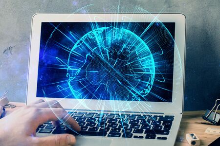 Double exposure of businessman working on laptop on background. International business hologram in front. Concept of success.の写真素材
