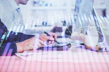 Forex graph with businessman working on computer in office on background. Concept of hardworking. Closeup. Multi exposure.の写真素材
