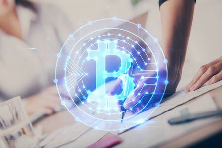 Cryptocurrency hologram over womans hands writing background. Concept of blockchain. Multi exposureの写真素材