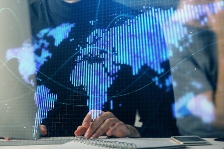 Double exposure of businessman working on laptop on background. International business hologram in...