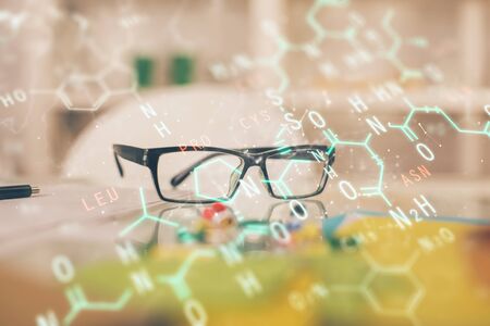 Formulas drawing with glasses on the table background. Concept of science. Double exposure.の写真素材