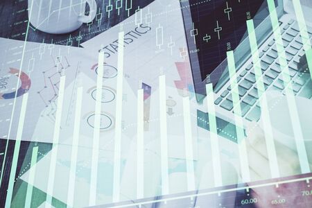 Double exposure of stock graph with businessman typing on computer in office on background. Concept of hard work.の写真素材