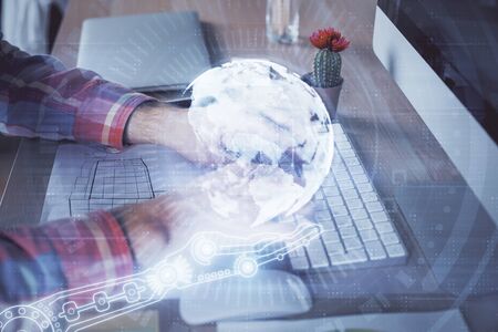 Multi exposure of world map hologram with man working on computer on background. Concept of worldwideweb.の写真素材