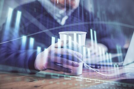 Forex graph with businessman working on computer in office on background. Concept of hardworking. Closeup. Multi exposure.の写真素材