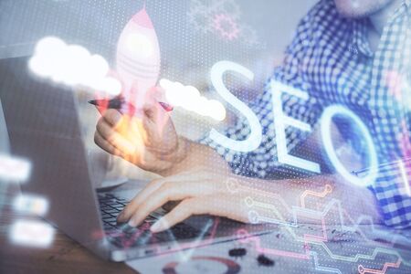 Double exposure of seo icon with man working on computer on background. Concept of search engine optimization.の写真素材