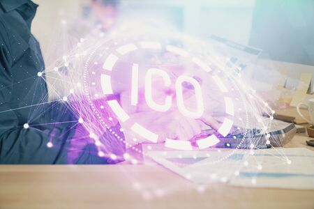 Crypto currency theme hologram with businessman working on computer on background. Concept of blockchain. Multi exposure.の写真素材